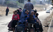 Palestinians fleeing Gaza City and other parts of northern Gaza, carry some belongings as...