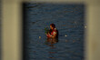 Devotees are seen offering their prayer to setting sun , during Chhath puja festival in Ko...