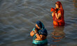 Devotees are seen offering their prayer to setting sun , during Chhath puja festival in Ko...