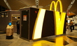 A McDonald's employee is taking out hamburgers delivered by a delivery robot from Chinese...