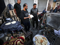 Displaced Palestinians are baking bread in Al-Maghazi camp in the central Gaza Strip on November 30, 2023, on the seventh day of a truce bet...