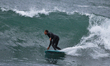 A surfer is riding the waves at Spot Secret in Livorno, Italy, on March 2021. 