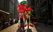 Revelers are in the holiday spirit, carrying inflatable Christmas decorations down the str...