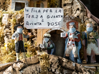 Cribs figurines wearing covid19 masks and holding a banner with a sarcastic message about Covid-19 vaccine is seen in San Gregorio Armeno st...