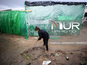 A Palestinian girl is standing amidst the rain at a camp for displaced people in Deir El-Balah, in the central Gaza Strip, where many civili...
