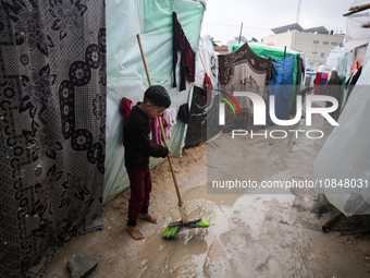 A Palestinian boy is standing amidst the rain at a camp for displaced people in Deir El-Balah, in the central Gaza Strip, where many civilia...