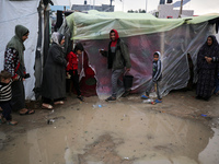 Palestinians are taking refuge amid the rain at a camp for displaced people in Deir El-Balah, in the central Gaza Strip, as battles continue...