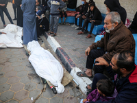 Palestinians are mourning the death of loved ones following an Israeli bombardment in Deir Al-Balah, in the central Gaza Strip, on December...