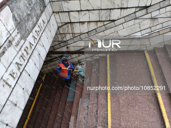 A utility worker is clearing snow from the stairs in Kyiv, Ukraine, on December 14, 2023. 
