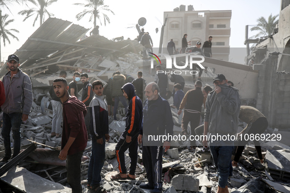 Palestinians are gathering around the destroyed home of the Hajj family following an Israeli bombardment at Nuseirat camp in the central Gaz...