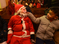 A boy dressed as Santa Claus is attending a ceremony inside the Holy Family Catholic Church in Srinagar, Indian Administered Kashmir, on Dec...