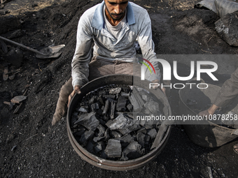 An Egyptian laborer is sifting charcoal at the charcoal factory in Al Bostan, Beheira Governorate, Egypt, on December 17, 2023.  (