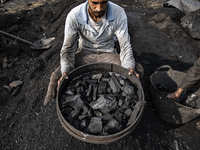 An Egyptian laborer is sifting charcoal at the charcoal factory in Al Bostan, Beheira Governorate, Egypt, on December 17, 2023.  (