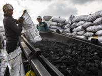 Egyptian laborers are sifting charcoal for shipping at the charcoal factory in Al Bostan, Beheira Governorate, Egypt, on December 17, 2023....