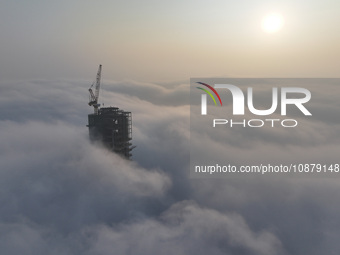 Workers are working on the 416.6-meter-high Hexi City II roof in heavy fog in Nanjing, Jiangsu Province, China, on December 29, 2023. (