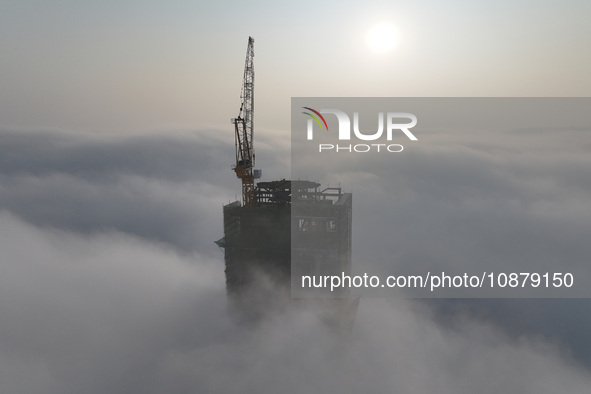 Workers are working on the 416.6-meter-high Hexi City II roof in heavy fog in Nanjing, Jiangsu Province, China, on December 29, 2023. 