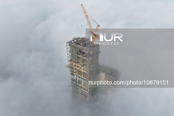 Workers are working on the 416.6-meter-high Hexi City II roof in heavy fog in Nanjing, Jiangsu Province, China, on December 29, 2023. 