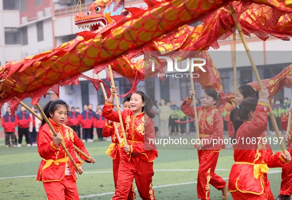 Primary school students are performing a traditional dragon dance in Hefei, Anhui province, China, on December 29, 2023. 