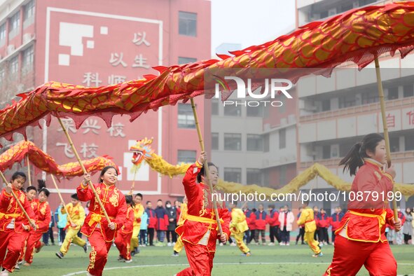 Primary school students are performing a traditional dragon dance in Hefei, Anhui province, China, on December 29, 2023. 