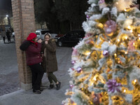 Two Iranian-Christian women are standing together next to a Christmas tree at the Saint Targmanchats Church in eastern Tehran, during a New...