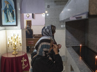 Two Iranian-Christian women are praying after lighting candles at the Saint Targmanchats Church in eastern Tehran, during a New Year mass pr...