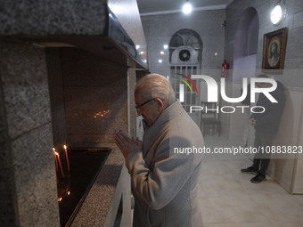 An elderly Iranian-Christian man is praying after lighting candles at the Saint Targmanchats Church in eastern Tehran, during a New Year mas...