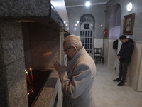 An elderly Iranian-Christian man is praying after lighting candles at the Saint Targmanchats Church in eastern Tehran, during a New Year mas...