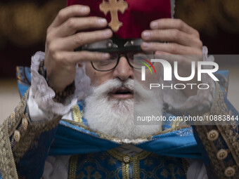 A clergyman is holding up a holy bible at the Saint Targmanchats Church in eastern Tehran, during a New Year mass prayer ceremony, on Januar...