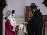 A clergyman is picking up holy bread at the Saint Targmanchats Church in eastern Tehran, during a New Year mass prayer ceremony, on January...