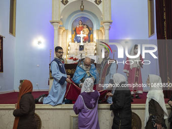 Iranian-Christian women are receiving holy bread from a clergyman at the Saint Targmanchats Church in eastern Tehran, after a New Year mass...