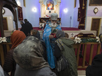 Iranian-Christian women are praying as a clergyman holds a holy bible at the Saint Targmanchats Church in eastern Tehran, after a New Year m...