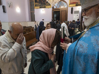 Iranian-Christian people are praying as a clergyman holds a holy bible at the Saint Targmanchats Church in eastern Tehran, after a New Year...