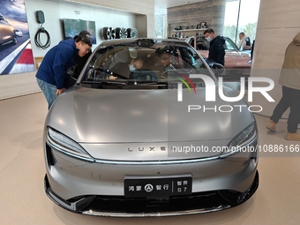 Customers are selecting and buying new energy vehicles at the flagship store in Shanghai, China, on January 2, 2024. (