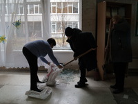 Employees are putting glass shards into a sack at school N221, which was damaged during the Russian missile attack, in Kyiv, Ukraine, on Jan...
