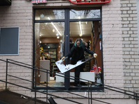 A shop assistant in the Dorohozhychi district is throwing shards of window glass, broken by a Russian missile attack, into the street in Kyi...