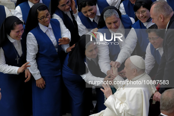 Pope Francis is greeting a group of nuns during the weekly general audience in Paul VI Hall at the Vatican on January 3, 2024. 