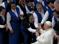 Pope Francis is greeting a group of nuns during the weekly general audience in Paul VI Hall at the Vatican on January 3, 2024. (
