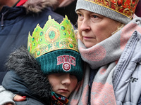 A boy and his grandmother, wearing a paper crown participate in a public Nativity Play performed on the street of Old Town of Krakow, Poland...
