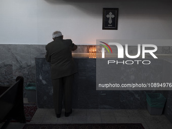 An elderly Iranian-Armenian man is lighting a candle and praying at the St. Vartan Armenian Church in central Tehran, while attending a Chri...