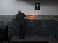 An elderly Iranian-Armenian man is lighting a candle and praying at the St. Vartan Armenian Church in central Tehran, while attending a Chri...