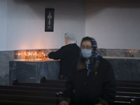 An elderly Iranian-Armenian woman is lighting a candle and praying at the St. Vartan Armenian Church in central Tehran while attending a Chr...