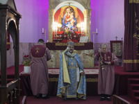 Iranian-Armenian clergymen are praying at the St. Vartan Armenian Church in central Tehran on January 6, 2024, as one of them is carrying a...