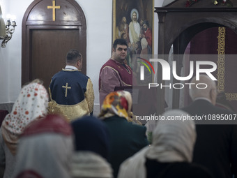 An Iranian-Armenian clergyman is looking on as worshippers are praying at the St. Vartan Armenian Church in central Tehran during a Christma...