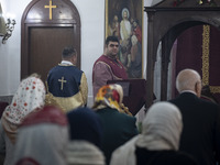 An Iranian-Armenian clergyman is looking on as worshippers are praying at the St. Vartan Armenian Church in central Tehran during a Christma...