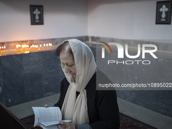 An Iranian-Armenian woman is praying at the St. Vartan Armenian Church in central Tehran during a Christmas mass prayer ceremony on January...