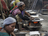 A woman is making Assamese traditional pitha (rice cake) ahead of the Magh Bihu, also known as Bhogali Bihu festival, in Guwahati, Assam, In...