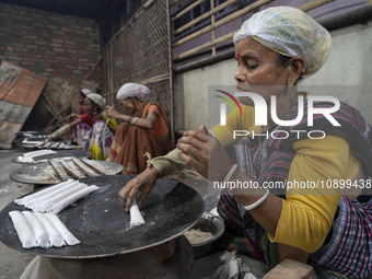 A woman is making Assamese traditional pitha (rice cake) ahead of the Magh Bihu, also known as Bhogali Bihu festival, in Guwahati, Assam, In...