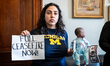 An activist prepares to leave a bloodied doll with staff in the office of Senator Kirsten...