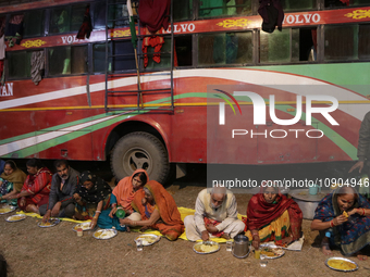 Hindu pilgrims are eating a meal in the open air at a transit camp while on their way to Ganganagar, a Hindu pilgrimage site that devotees v...