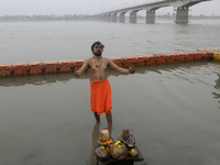 A man is singing a Ram bhajan song as he bathes near the Saryu river ghat ahead of the Ram temple opening in Ayodhya, Uttar Pradesh, India,...